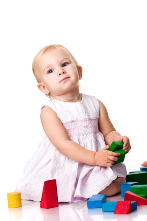 Beautiful baby building a castle with cubes isolated on whiteの写真素材