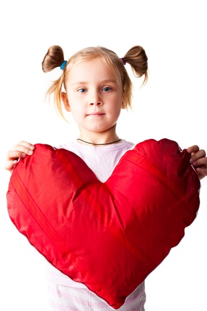 Beautiful girl with heart shaped pillow isolated on whiteの写真素材