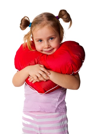 Beautiful girl with heart shaped pillow isolated on whiteの写真素材