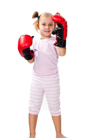 Beautiful girl in boxing gloves punching isolated on whiteの写真素材