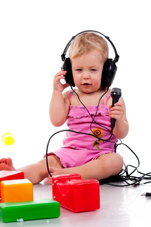 Baby with headphones and microphone, isolated on a white backgroundの写真素材