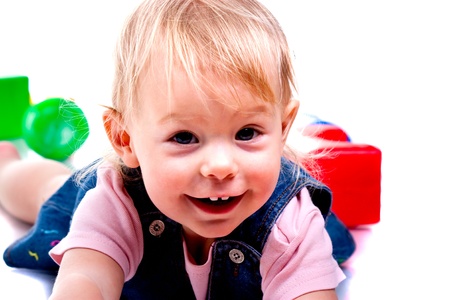 Beautiful baby playing building a castle with cubes isolated on whiteの写真素材