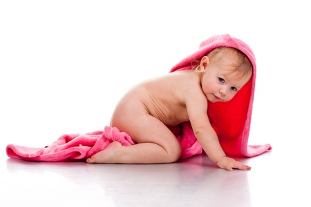 Beautiful girl curled under a pink blanket isolated on whiteの写真素材