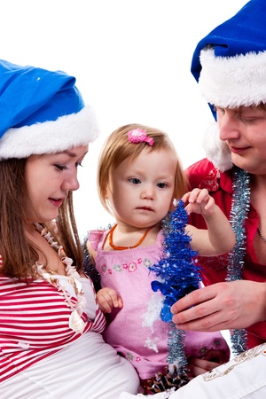 Family in Santa's hat sitting in artificial snow isolated on whiteの写真素材