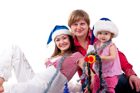 Family in Santa's hat sitting in artificial snow isolated on whiteの写真素材