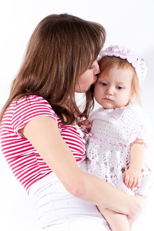 Mother kissing her daughter isolated on whiteの写真素材