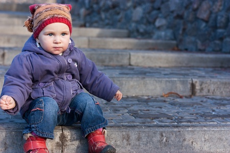Beautiful baby sitting on stairs outdoor の写真素材
