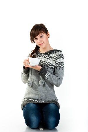 Beautiful girl holding a cup of tea isolated on whiteの写真素材