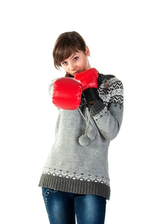Beautiful girl in boxing gloves punching isolated on whiteの写真素材