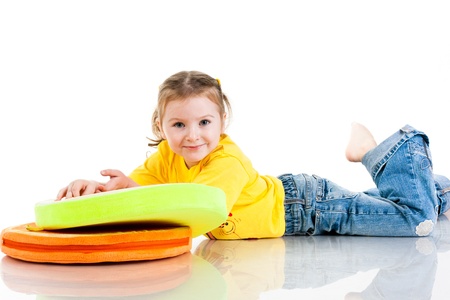 Beautiful baby girl holding a pillow isolated on whiteの写真素材