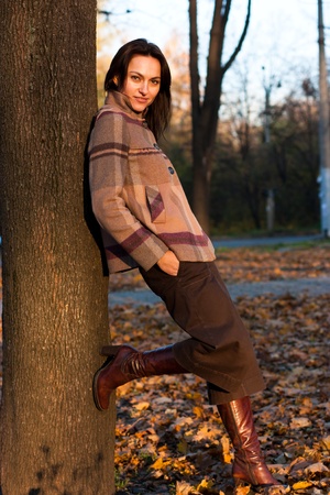 Beautiful young woman near the tree in autumnの写真素材