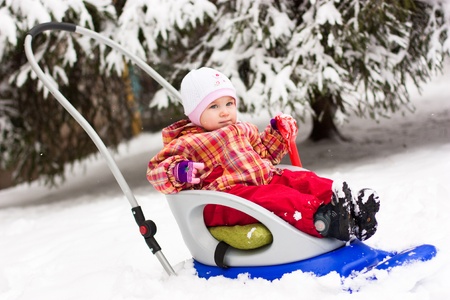 Beautiful girl in sled in winterの写真素材
