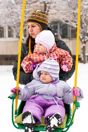 Mother and children in playground outdoor in winter の写真素材