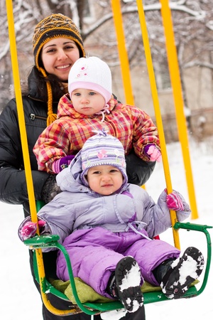 Mother and children in playground outdoor in winter の写真素材