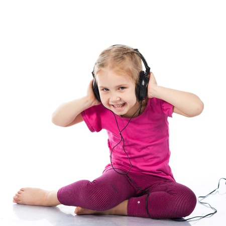 Beautiful girl in headphones listening to the music isolated on whiteの写真素材