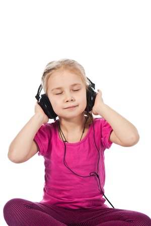 Beautiful girl in headphones listening to the music isolated on whiteの写真素材