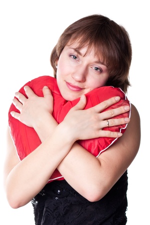 Beautiful young woman holding a heart isolated on whiteの写真素材