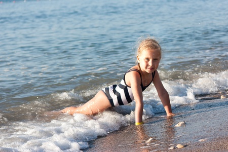Beautiful girl sitting on the beach at the seashoreの写真素材