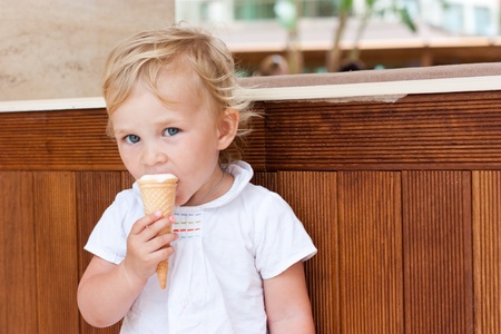 Cute child eating icecream outdoorの写真素材