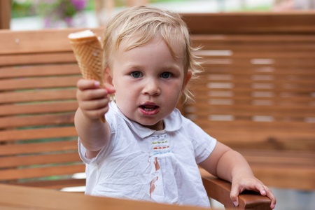 Cute child sharing her icecream outdoorの写真素材