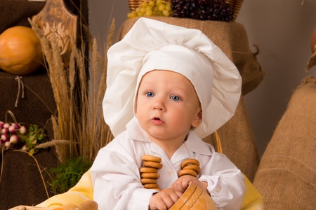 little boy in the cook costume at the kitchen の写真素材