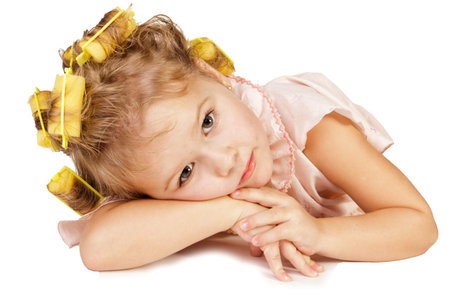 Beautiful little girl in rollers over white backgroundの写真素材