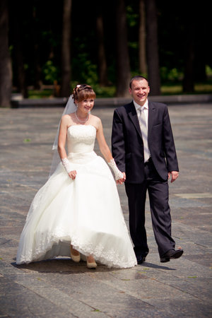 Happy bride and groom walking outdoorの写真素材