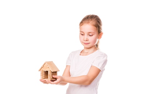 Beautiful little girl holding a toy model house isolated on white   Buying a house concept の写真素材