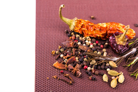 Various spices and herbs on a brown tablecloth with copyspace for you text