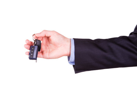 Male hand holding a car key isolated on white background  New car concept
