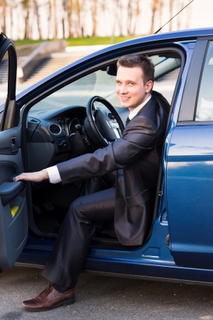 Handsome young businessman sitting in his new car の写真素材