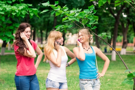 Group Of happy smiling Teenage Students outdoor Using Mobile Phoneの写真素材
