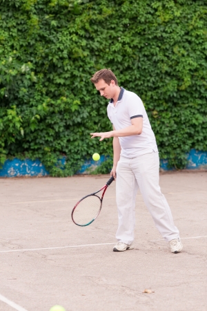 Expressive young man playing tennis outdoorの写真素材