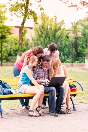 Group of happy smiling Teenage Students looking in laptopの写真素材