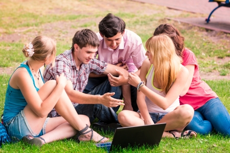 Group of happy smiling Teenage Students looking in laptopの写真素材