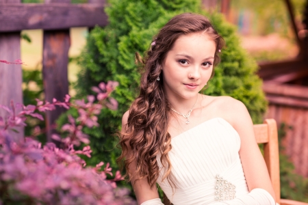 Charming little girl in a beautiful dress in a park outdoorの写真素材