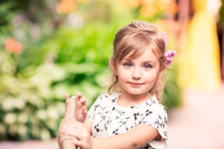 Charming little girl in a beautiful dress in a park outdoorの写真素材