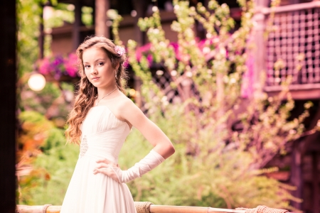 Charming little girl in a beautiful dress in a park outdoorの写真素材