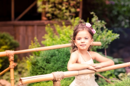 Charming little girl in a beautiful dress in a park outdoorの写真素材