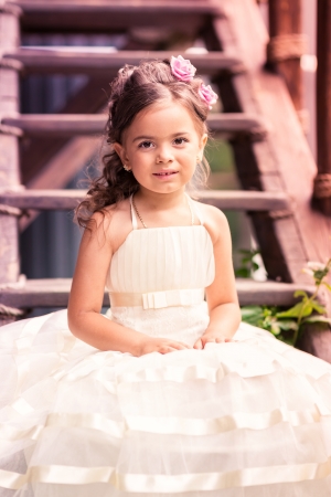 Charming little girl in a beautiful dress in a park outdoorの写真素材