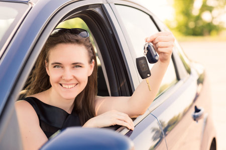 Beautiful businesswoman with carkey in her car
