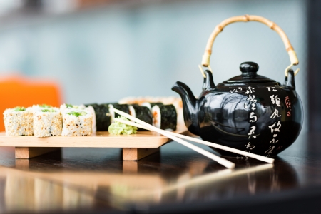Sushi rolls served on a wooden plate in a restaurantの写真素材