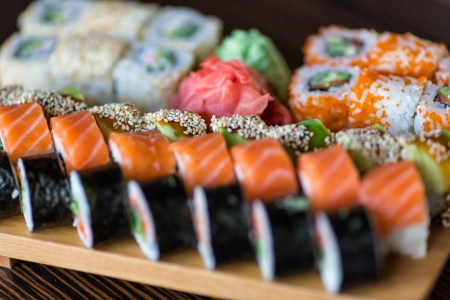 Sushi rolls served on a wooden plate in a restaurantの写真素材