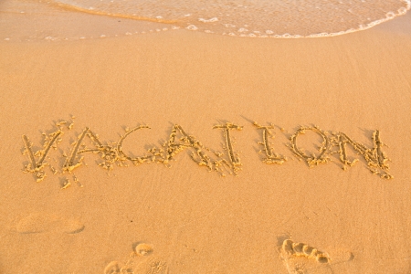 Word vacation on the yellow sandy beach, textの写真素材