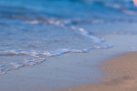 Soft wave of the sea on the sandy beach background