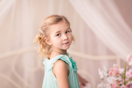 Cute little girl in fashion dress with spring flowersの写真素材