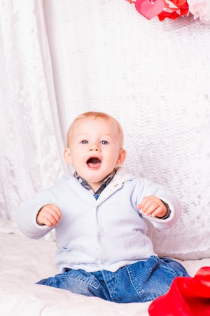 Cute happy baby boy on a bed playingの写真素材
