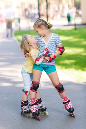 Two little girls rollerskating in the park outdoorの写真素材