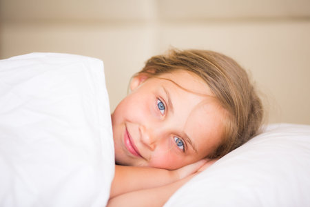 Adorable little girl sleeping in the bedの写真素材