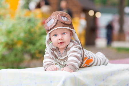 Adorable little baby lying in the park in a cute hatの写真素材